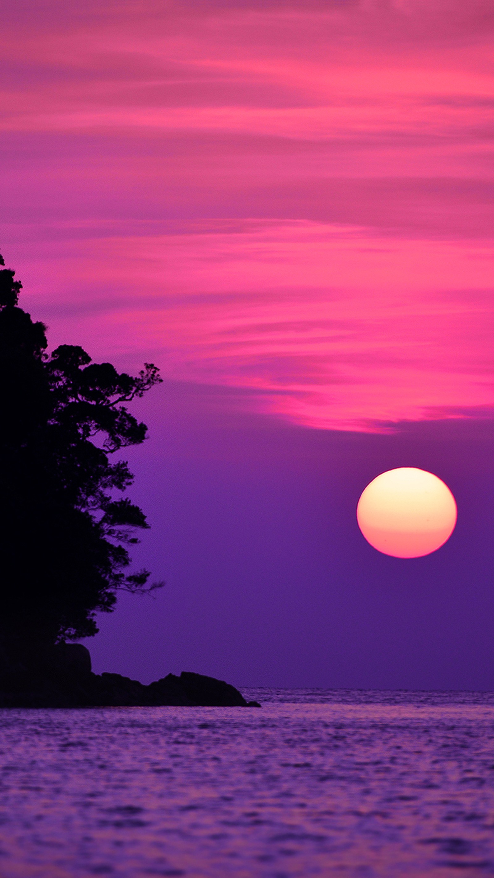 Un coucher de soleil violet et rose sur l'océan avec un bateau solitaire (paysage, rose, mer, soleil, coucher de soleil)