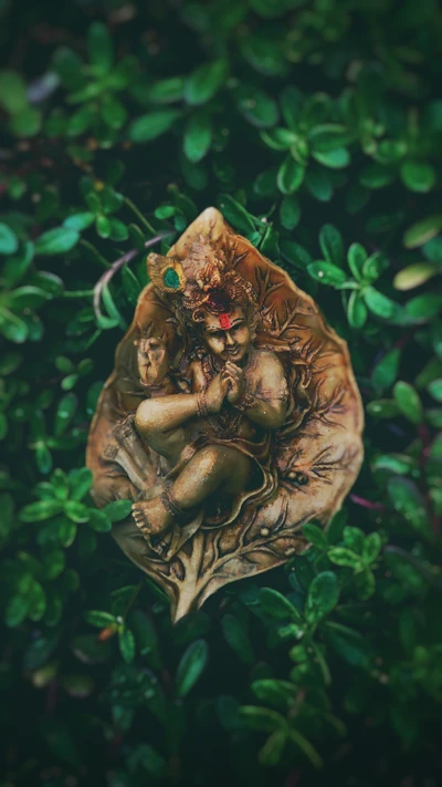 Figurine de Lord Krishna nichée dans la verdure