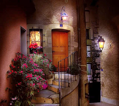 Encantadora entrada de casa con flores vibrantes y suave iluminación