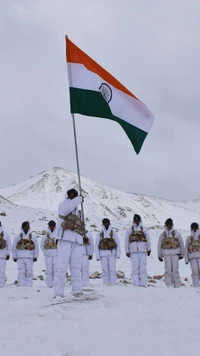 Soldados do exército indiano levantando a bandeira nacional em terreno nevado