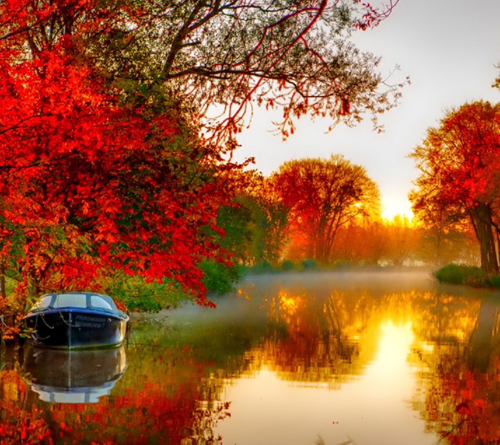 Un bateau arabe sur une rivière avec des arbres et du brouillard en arrière-plan (automne, coloré, nature)