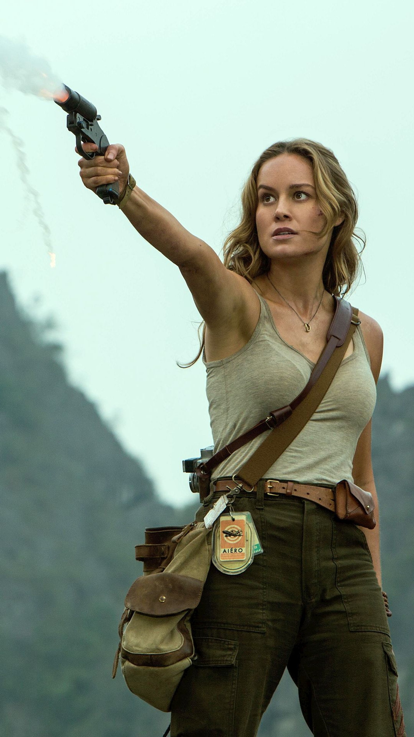 Verschwommenes bild einer frau mit einer waffe, die auf etwas in der luft zielt (2017, brie larson, kong, film, skull island)