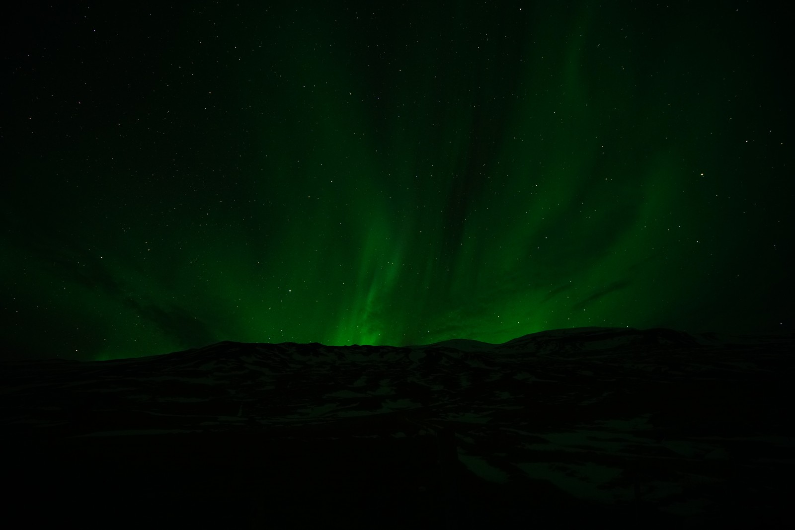 Ein grünes nordlicht über einem schneebedeckten berg mit einem himmel voller sterne (aurora, nacht, grün, schwarz, licht)