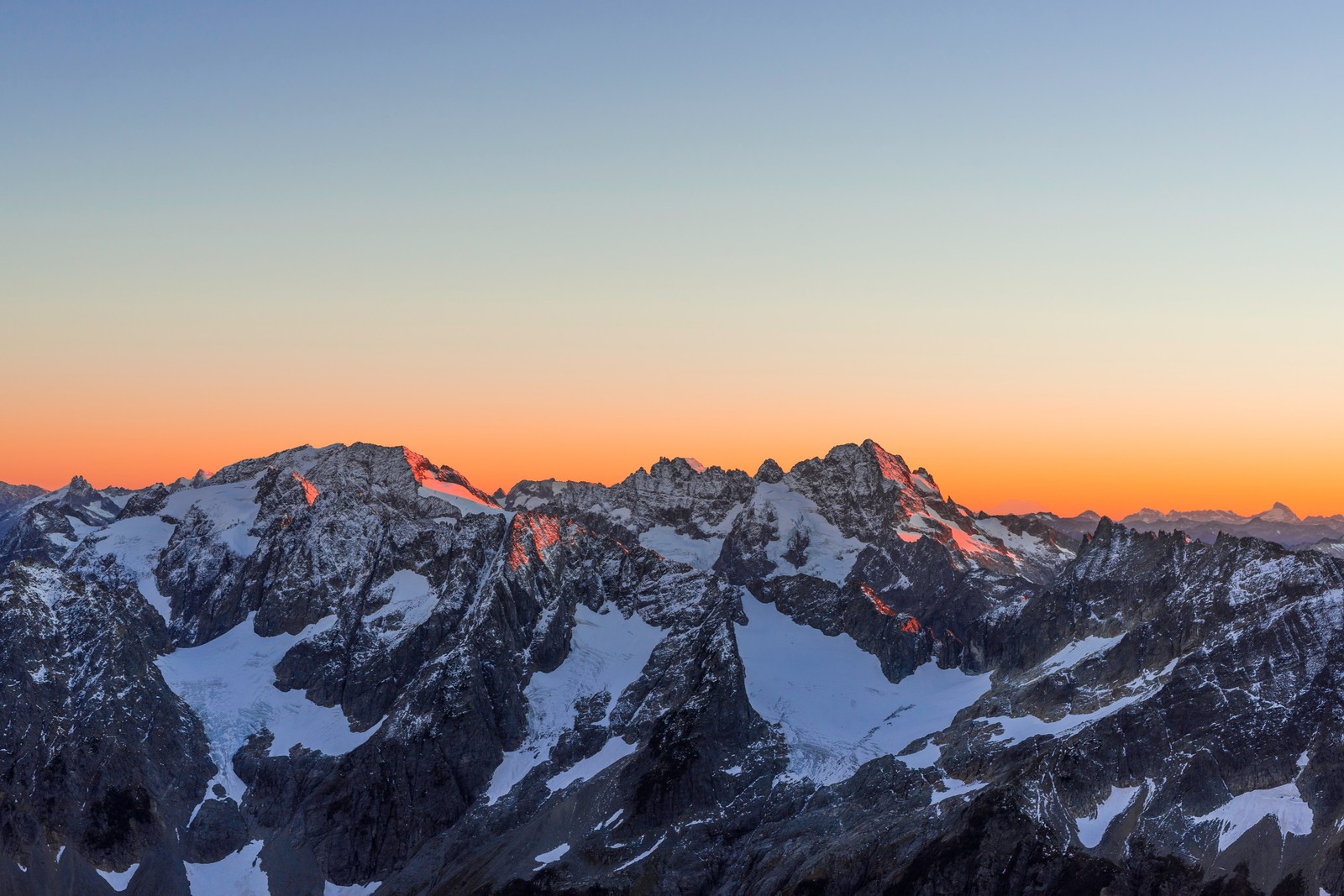 A view of a mountain range with snow covered mountains in the distance (sahale glacier campground, north cascades national park, glacier, sunset, dusk)