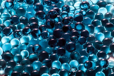 Close-up of Iridescent Glass Spheres on a Blue Background