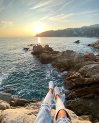 Sunset Serenity: Relaxing by the Rocky Shoreline