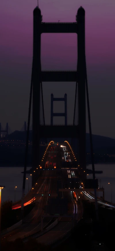 Midnight Cityscape: Illuminated Bridge and Roadway at Dusk