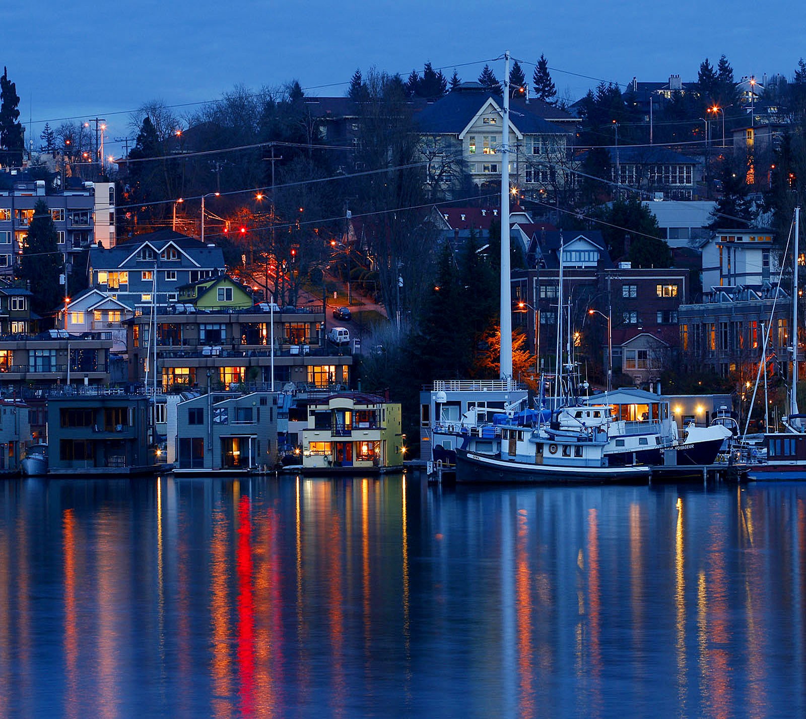 Boats are docked in a harbor at night with lights on (nature, wallpaper)