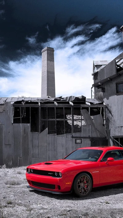 Challenger rojo en medio de ruinas industriales