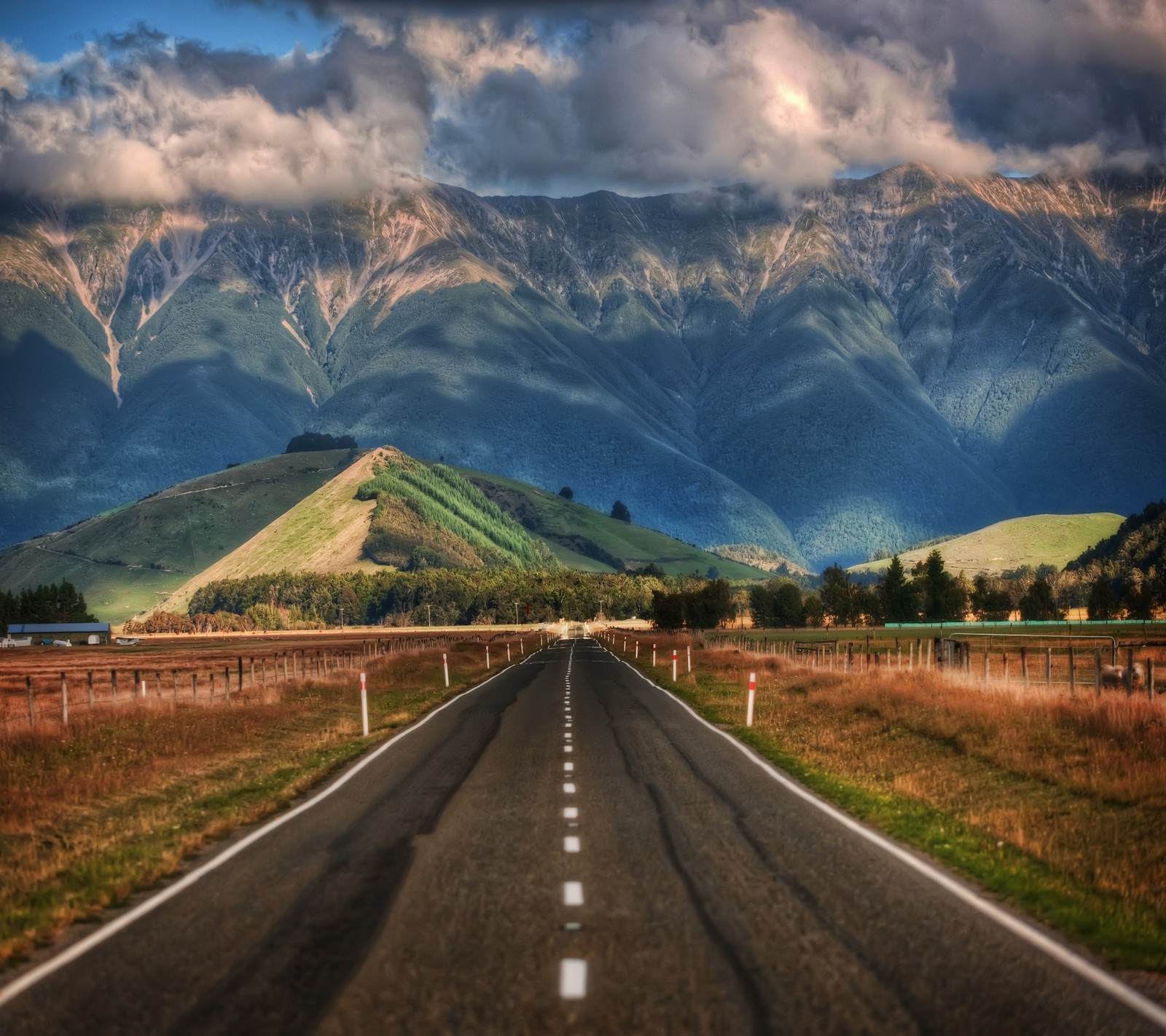 Vue aérienne d'une route avec des montagnes en arrière-plan et un ciel avec des nuages (montagne, nature, chemin, route)