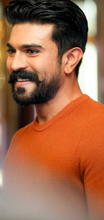 Ram Charan Smiling in a Stylish Orange Sweater