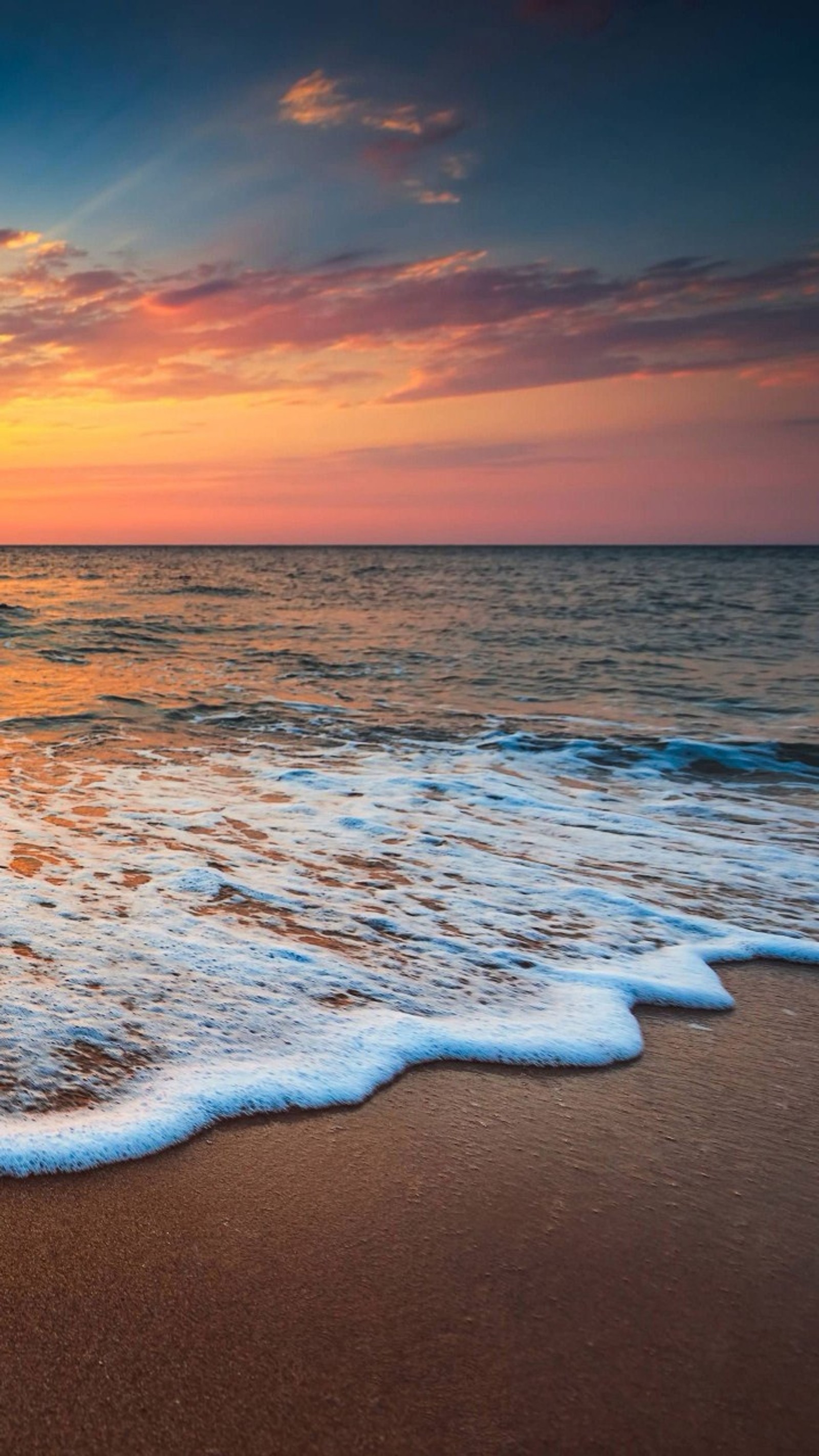 Puesta de sol sobre el océano con olas que llegan a la costa (mar, huawei, desbloquear revista)