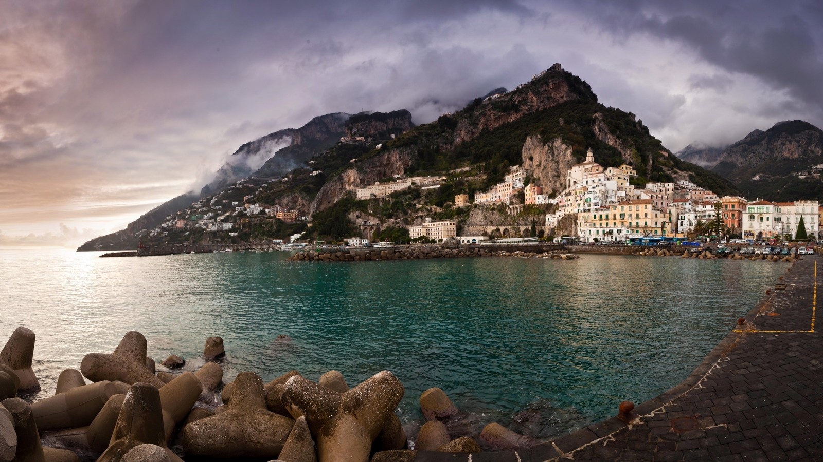 Há um grande corpo d'água com uma montanha ao fundo (positano, sorrento, costa, montanha, mar)