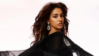 Disha Patani en un elegante vestido negro contra un fondo blanco