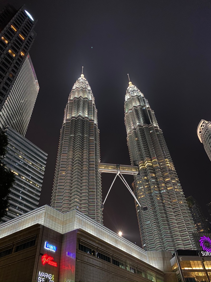 Араффатура города ночью с множеством высоких зданий (петронас, кuala lumpur, ночь, башенный блок, башня)