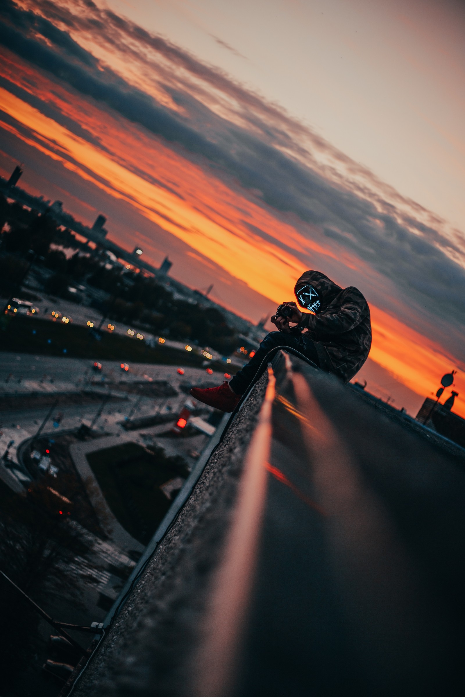 There is a person riding a skateboard on a bridge (cloud, atmosphere, water, asphalt, automotive lighting)