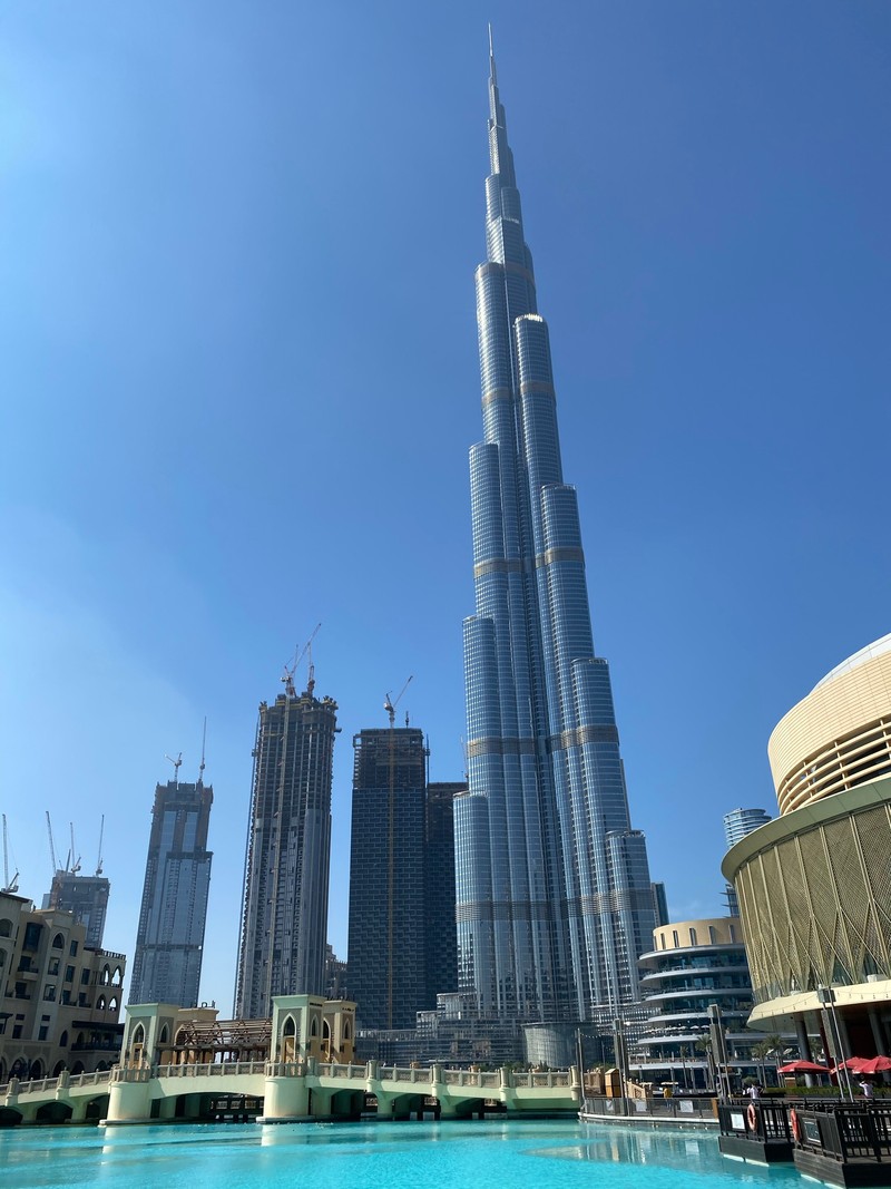 Вид на большое здание с бассейном перед ним (дубай, dubai, burj khalifa, небоскреб, дневное время)