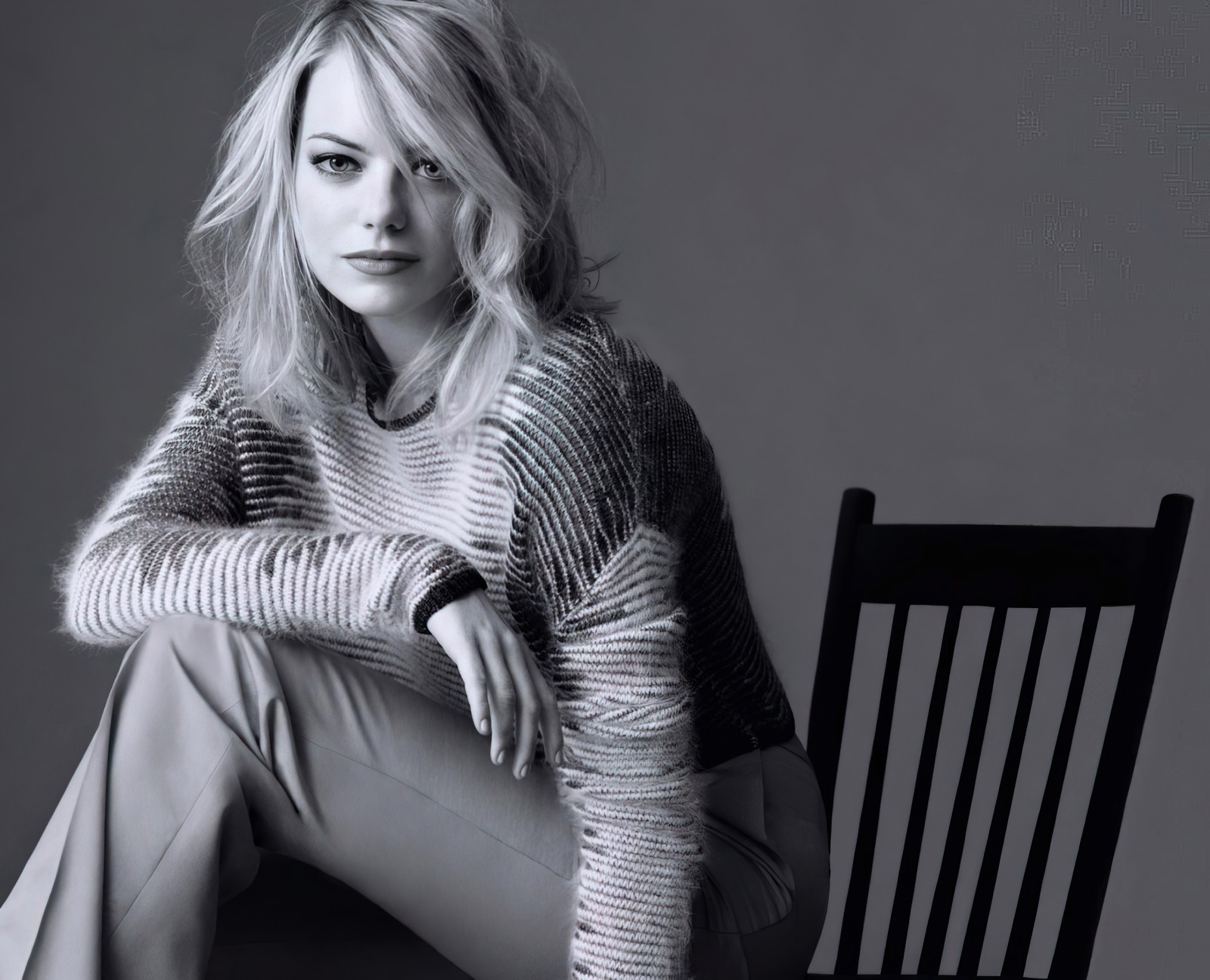 Femme blonde assise sur une chaise dans une photo en noir et blanc (emma stone, monochrome, actrice américaine, belle actrice, 5k)