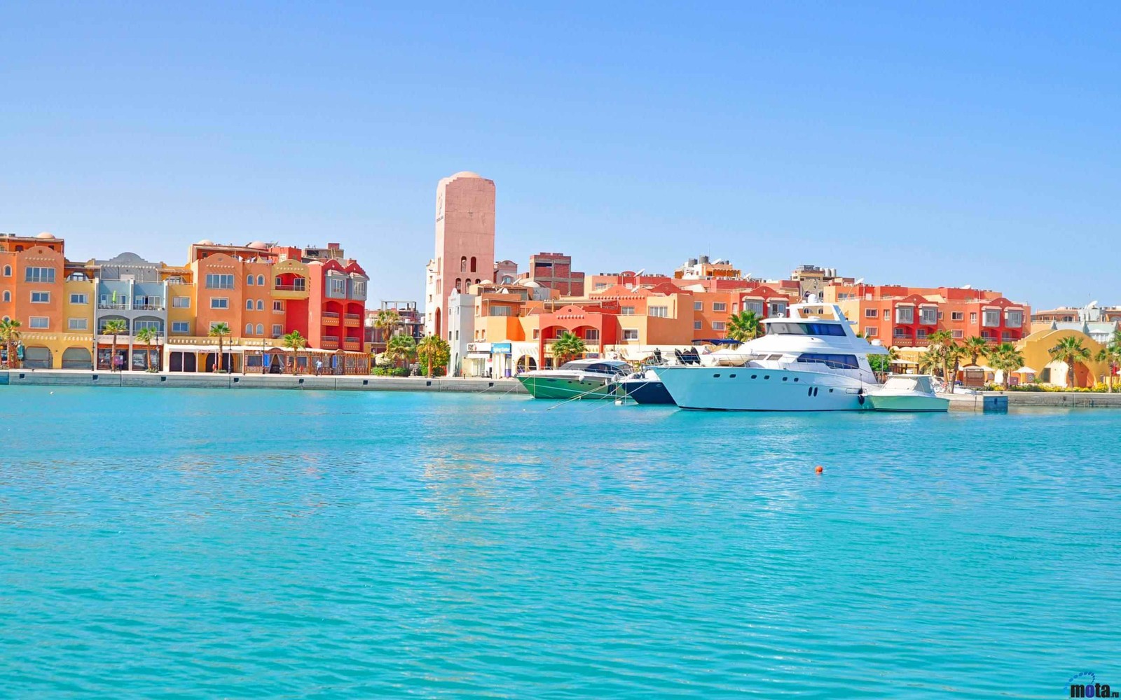 Boote liegen im wasser in der nähe einer stadt mit hohen gebäuden (tourismus, wassertransport, stadt, meer, wasserstraße)