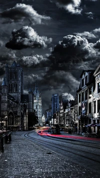 Paysage nocturne coloré d'une ville avec une architecture historique et des nuages dramatiques