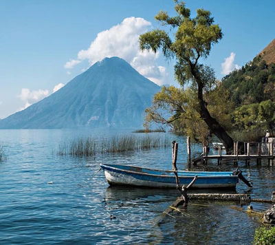 Vista serena del lago con un bote y fondo montañoso