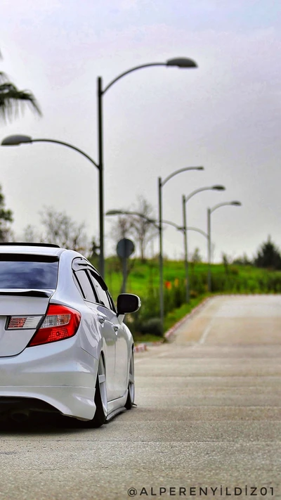 Elegante Honda Civic blanca en una tranquila carretera urbana