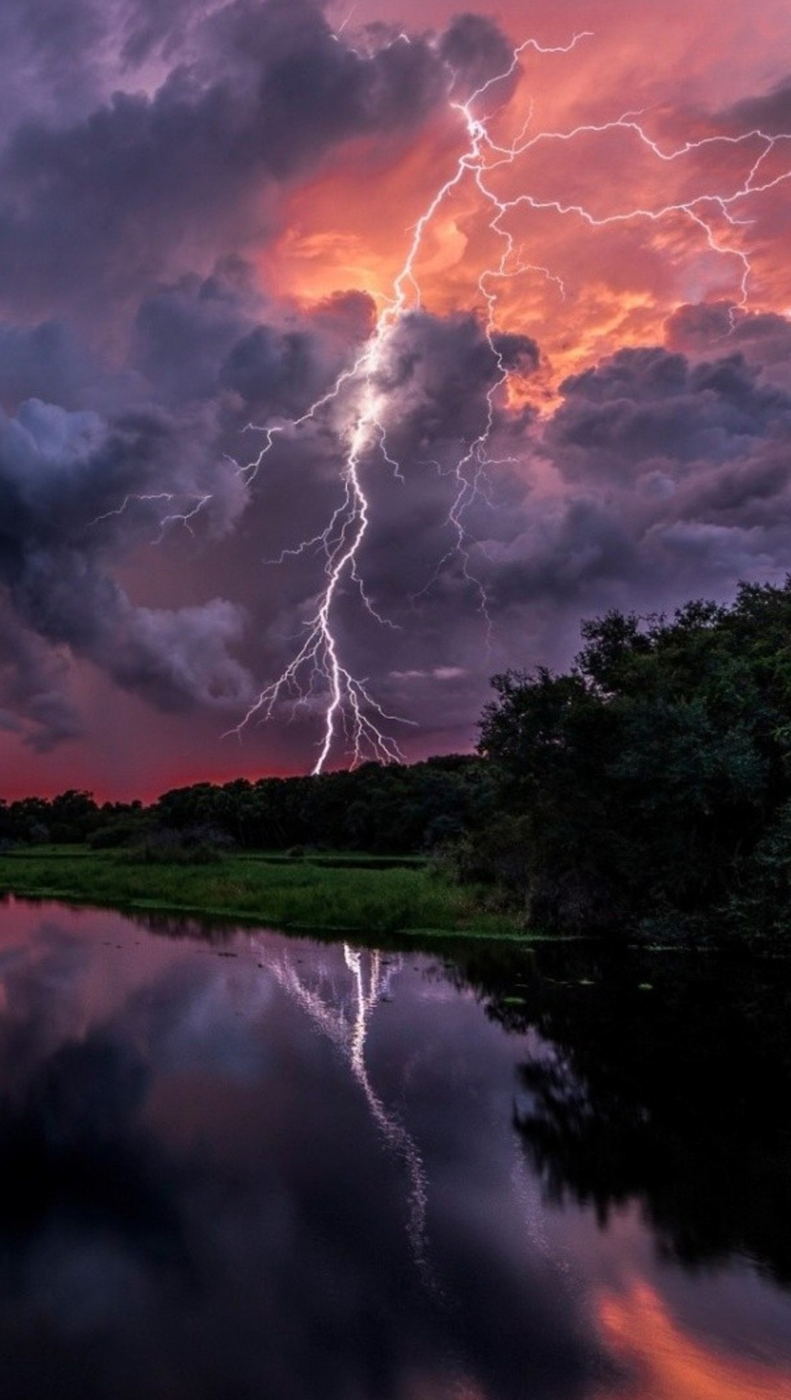 A close up of a lightning bolt hitting a body of water (lightning, river, sky, storm)