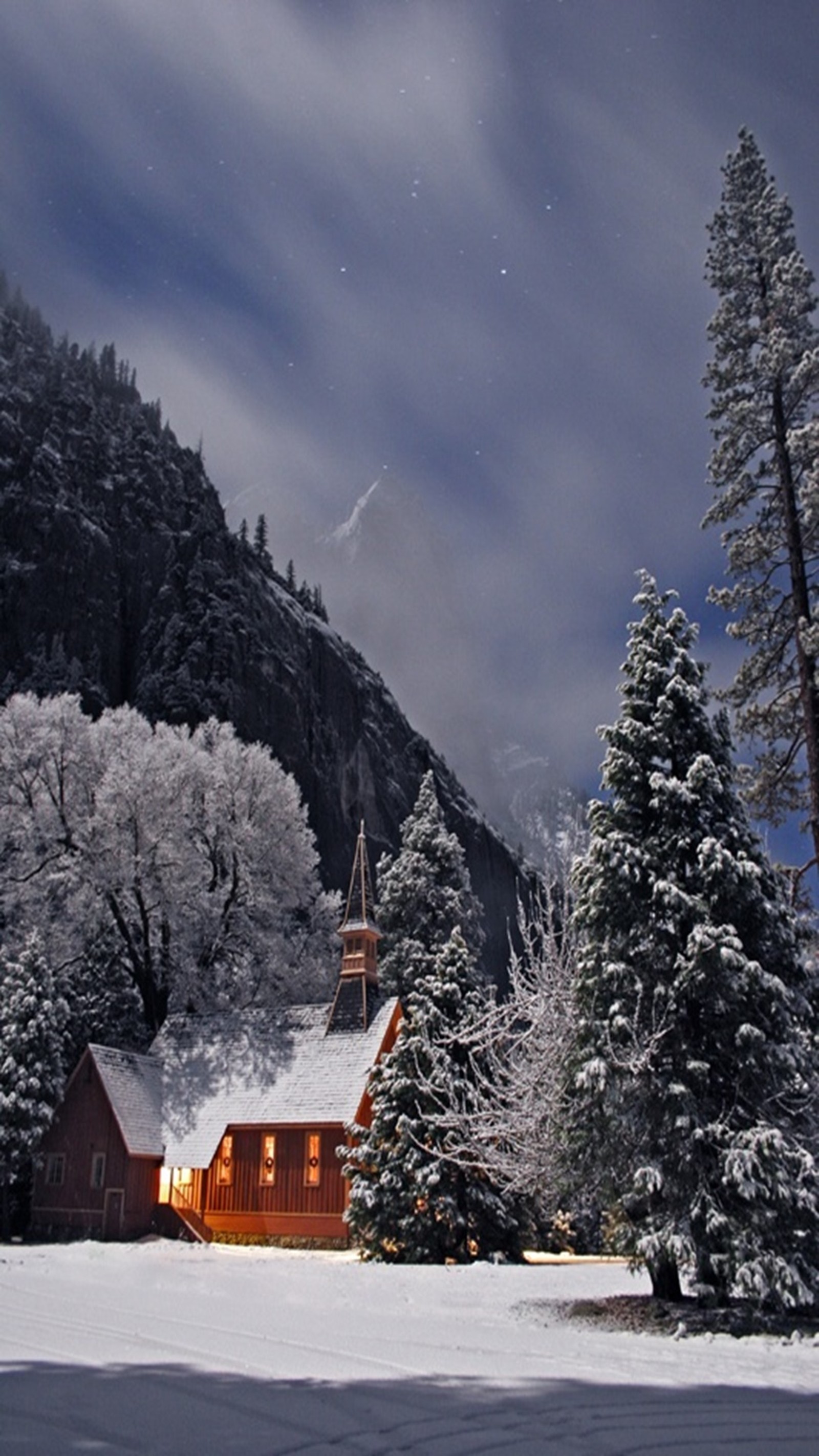 Scène enneigée d'un chalet dans les montagnes avec une montagne en arrière-plan (nuit, enneigé)