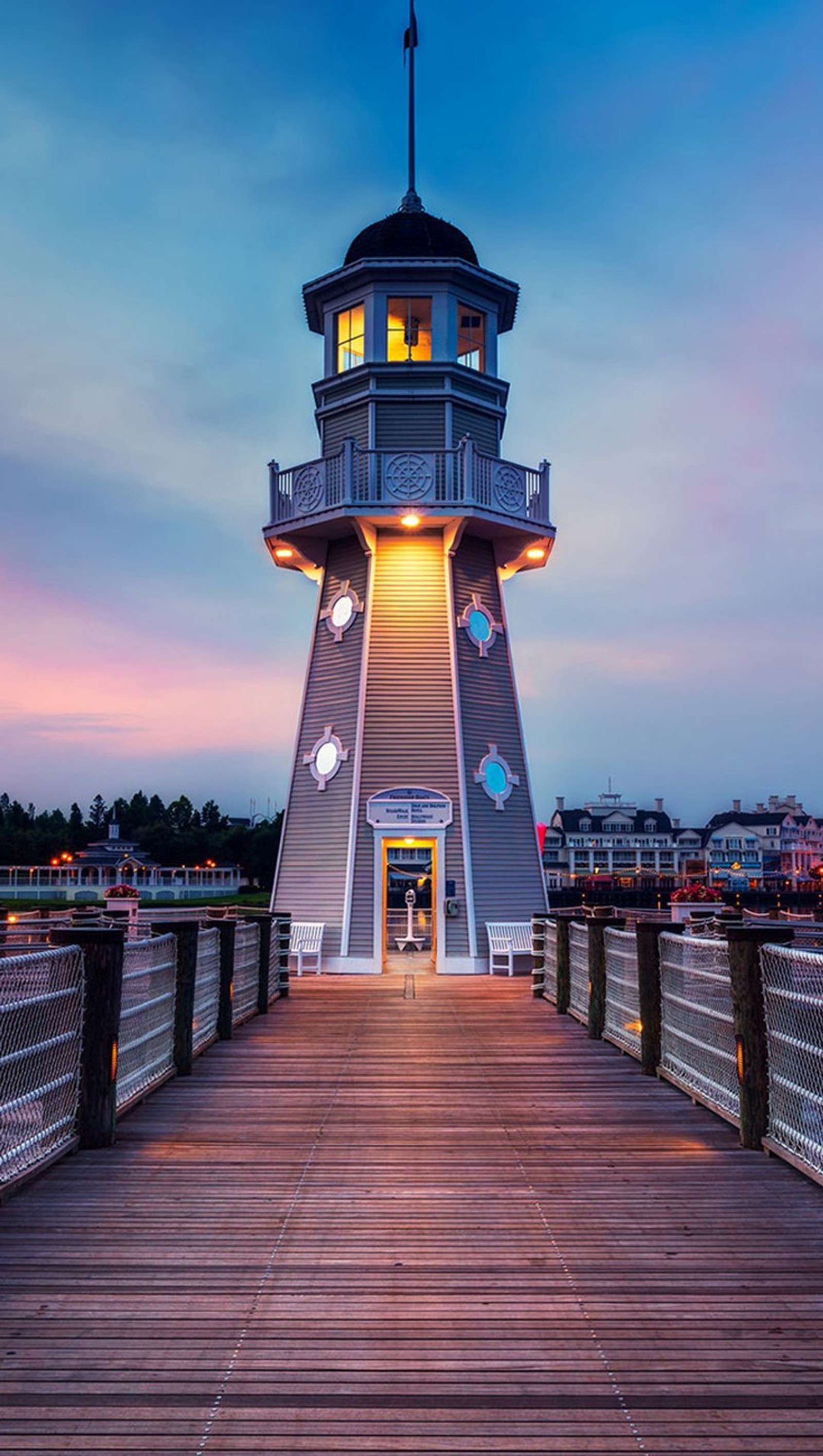 Farol panorâmico com uma bandeira no topo ao entardecer (azul, farol, céu, branco, madeira)