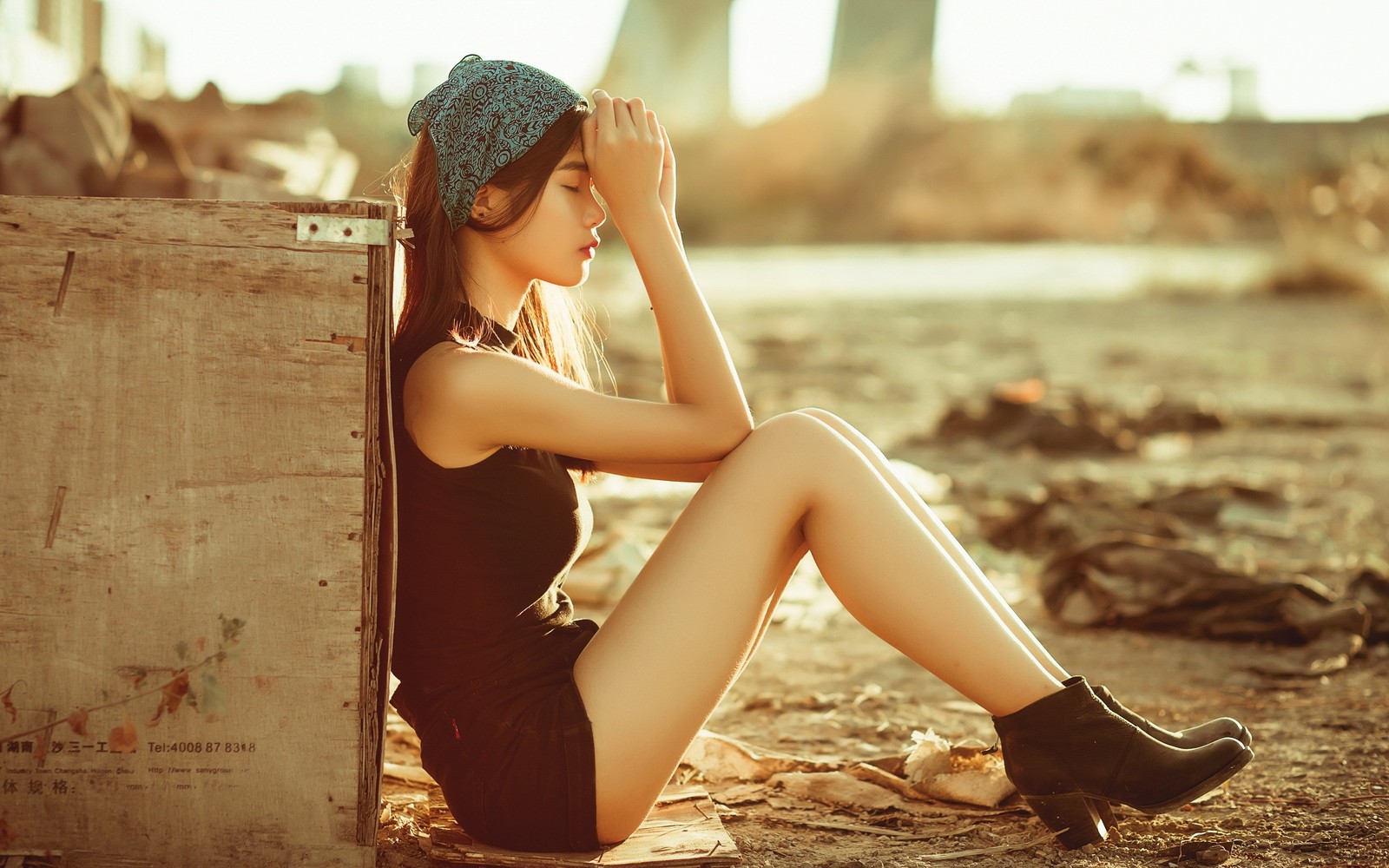 Araffe woman sitting on the ground with her head in her hands (beauty, sunlight, leg, sitting, summer)