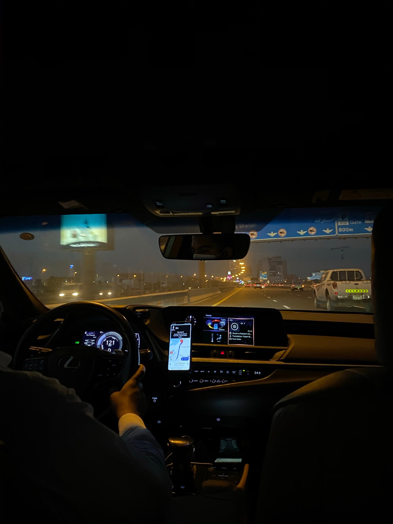 Arafed view of a man driving a car at night (windshield, automotive mirror, road, night, steering part)