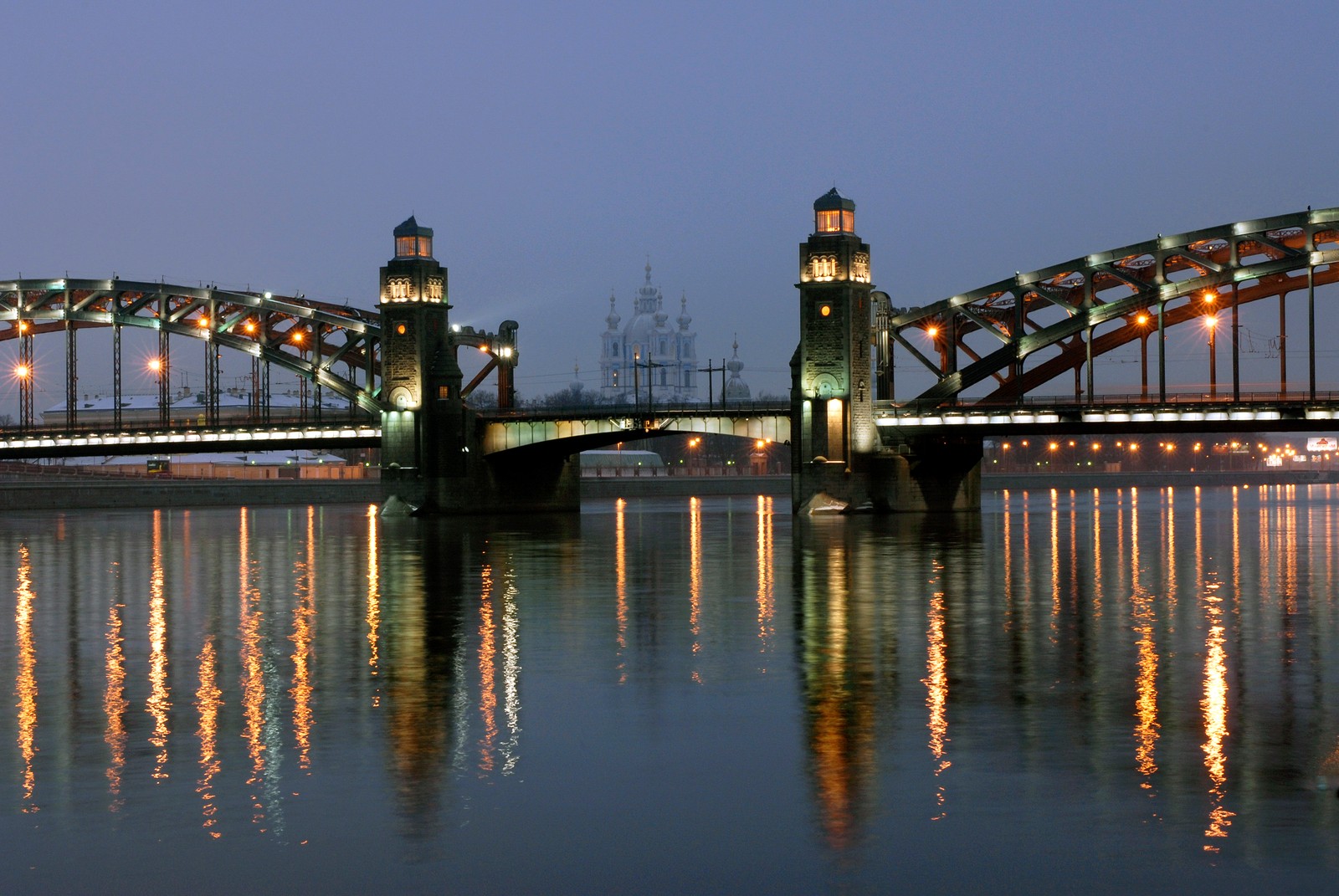 Uma ponte sobre um rio com uma torre do relógio à noite (ponte, reflexo, água, noite, flúmen)