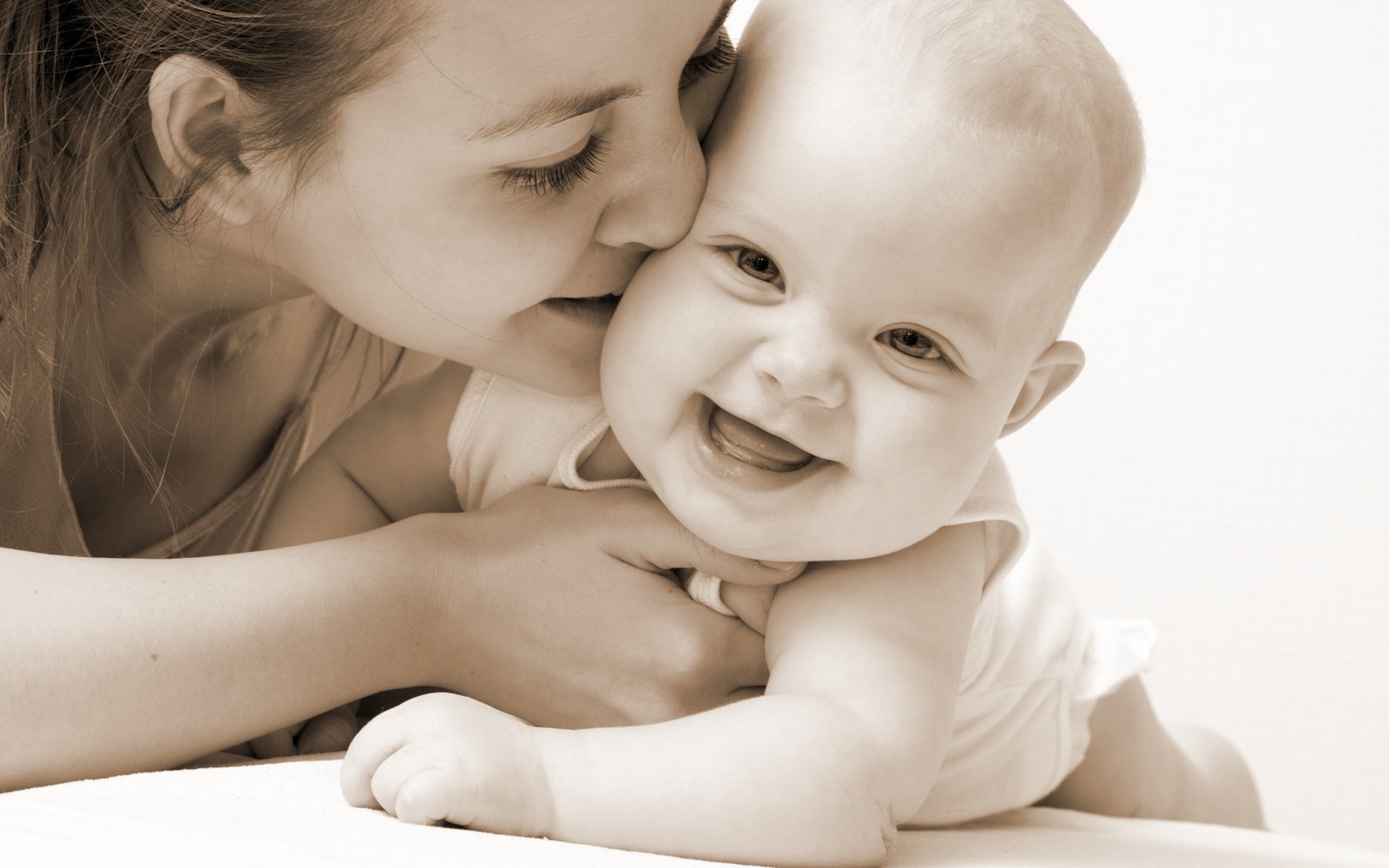 Une femme embrasse un bébé sur la joue (nourrisson, enfant, câlin, douceur, fille)