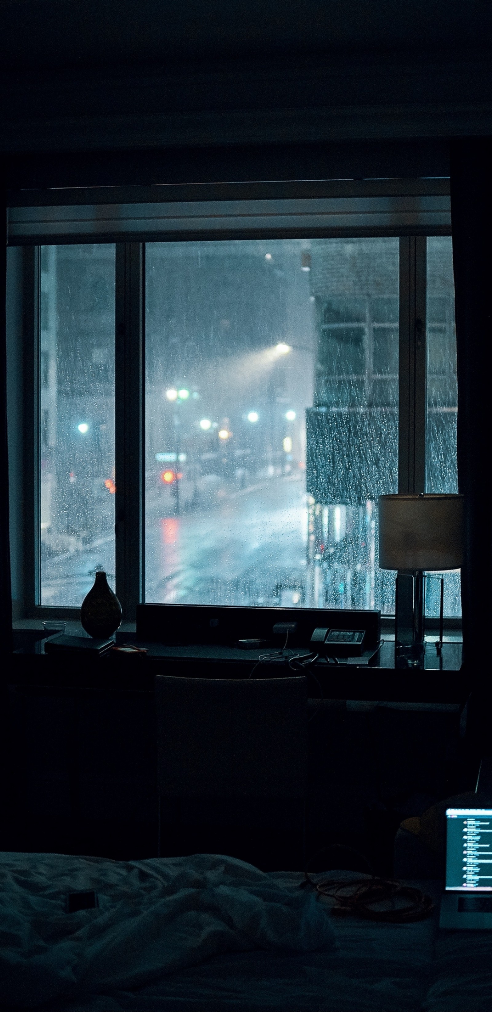 There is a laptop on a bed in front of a window (aesthetics, rain, window, building, shade)