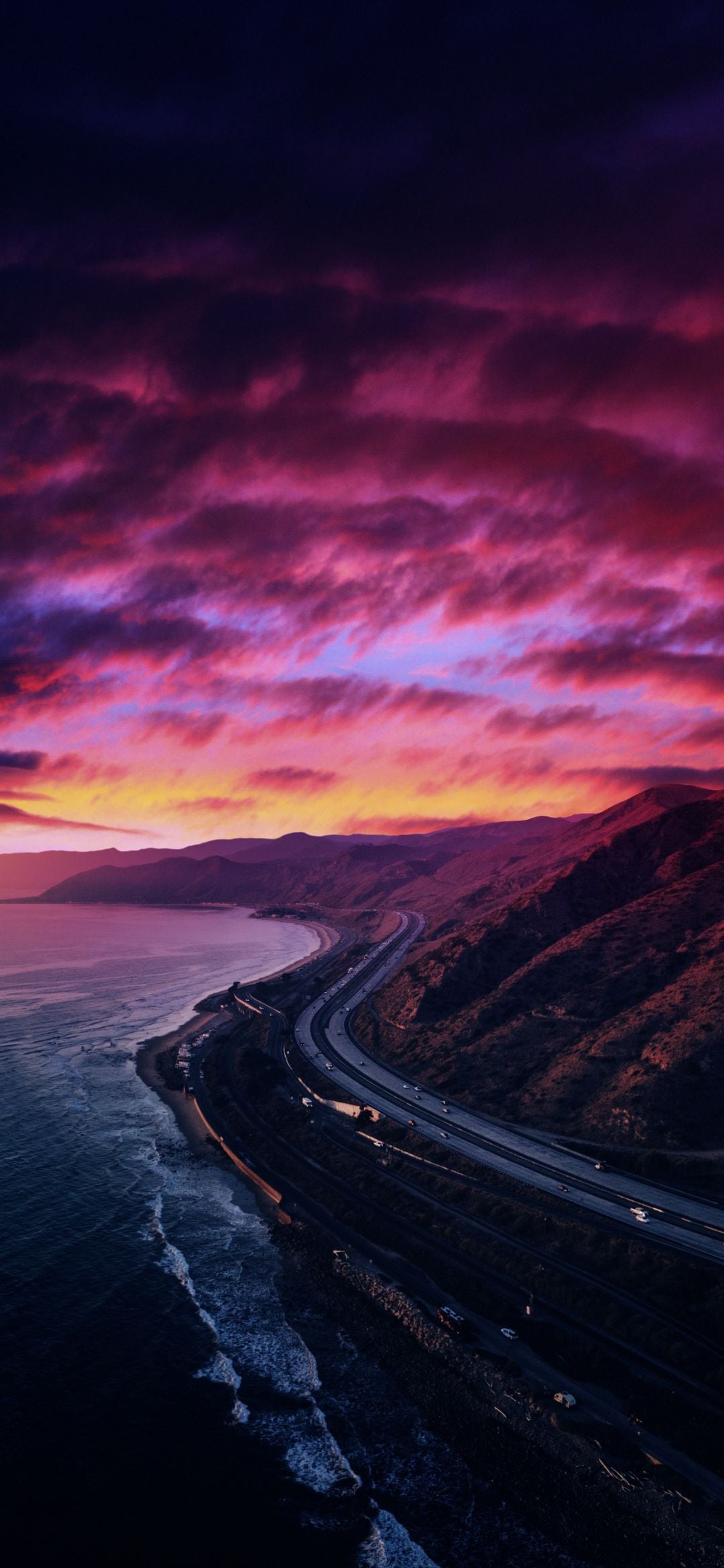 Vue aérienne d'une autoroute avec un coucher de soleil en arrière-plan (horizon, nuage, atmosphère, eau, paysage naturel)