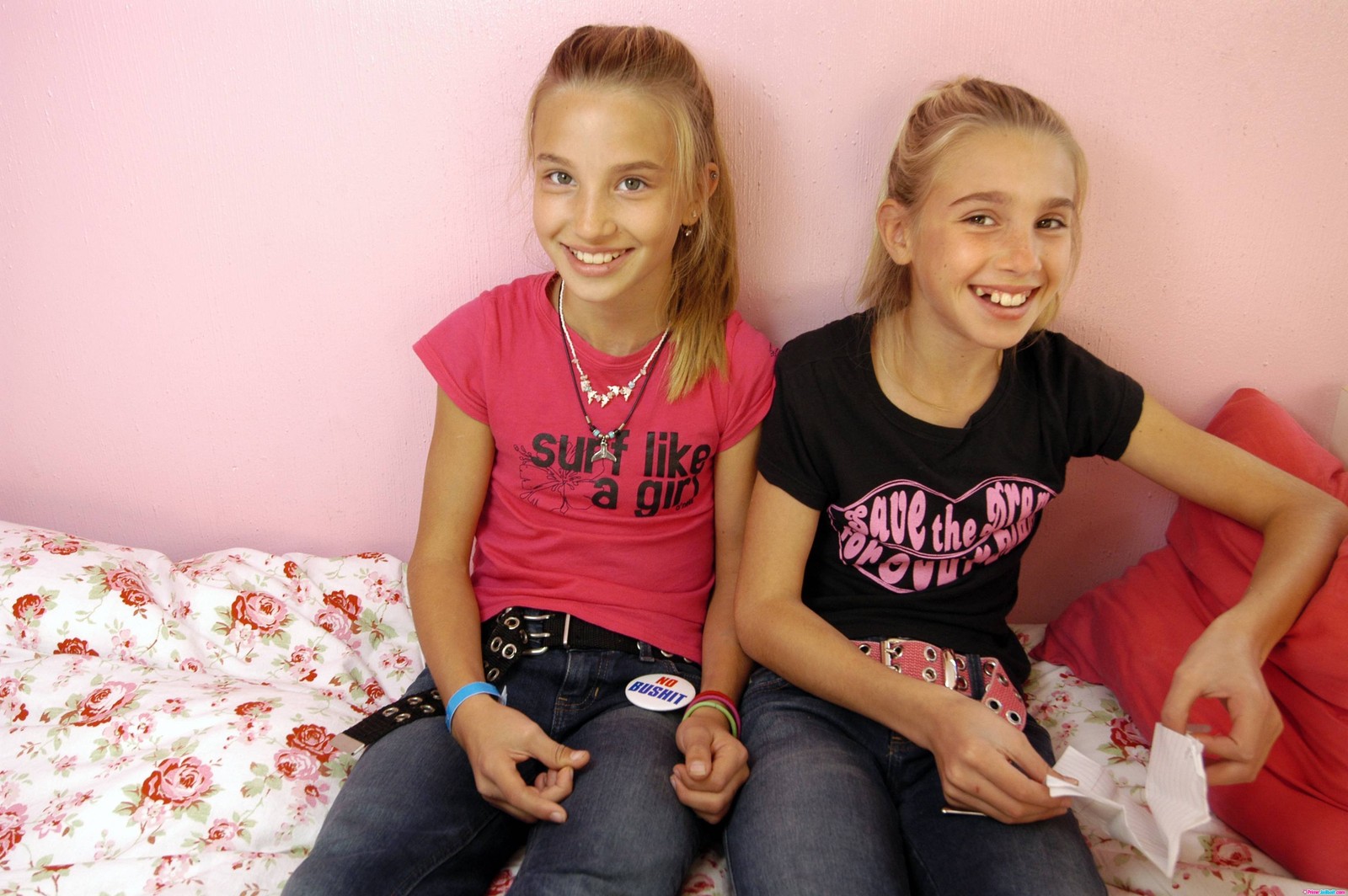 Deux filles assises sur un lit avec un mur rose et un mur rose (rose, enfant, amusement, amitié, sourire)