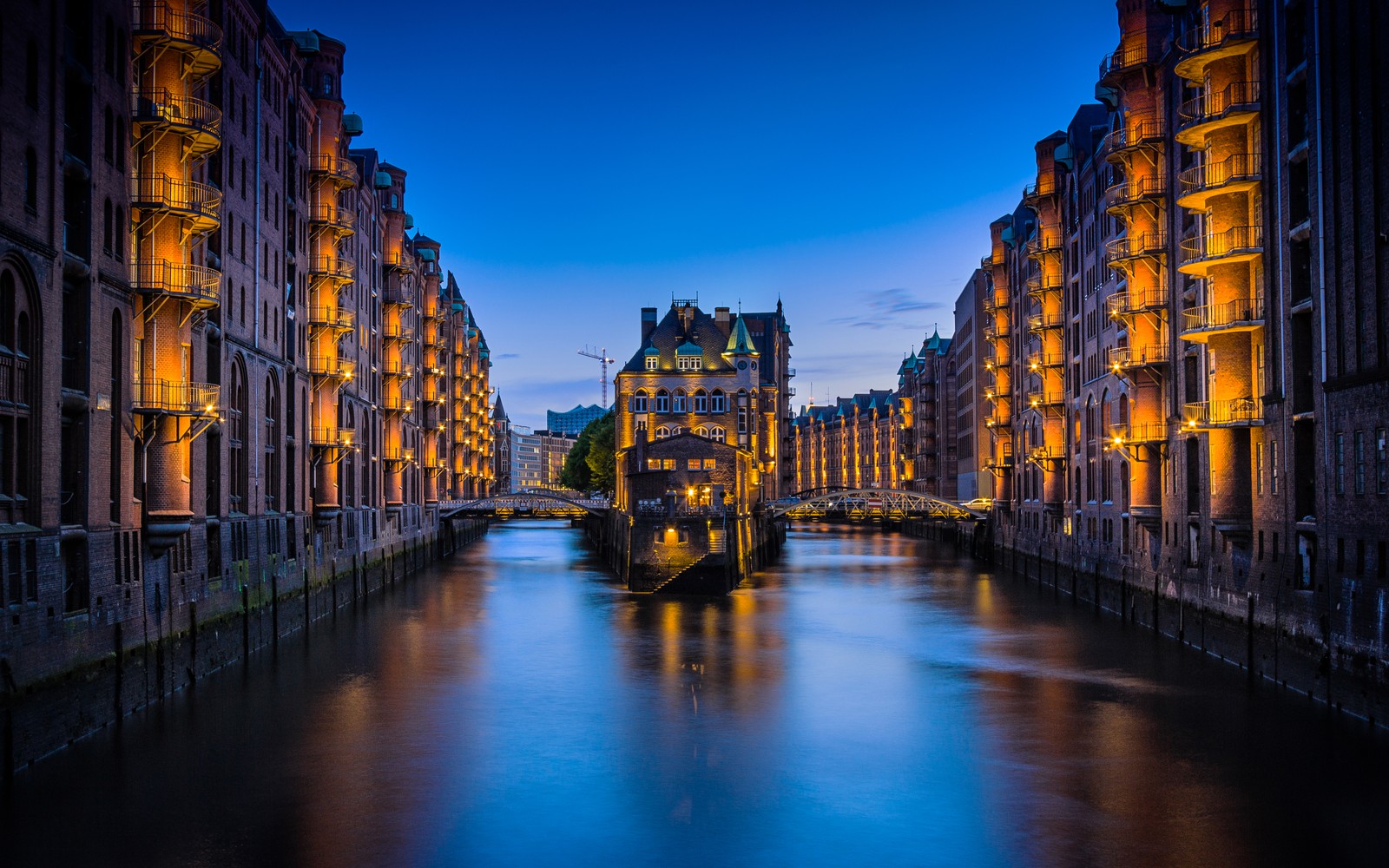 Вид на канал с зданиями и мостом на заднем плане (speicherstadt, гамбург, германия, городской пейзаж, здания)