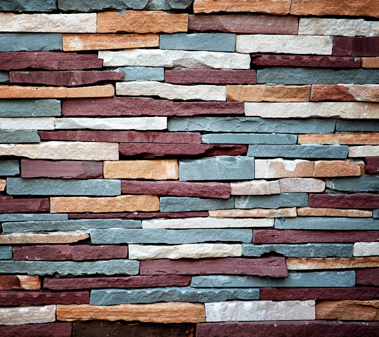 Un primer plano de una pared de ladrillos con un hidrante frente a ella (fondo, colorido, natural, piedras, pared)