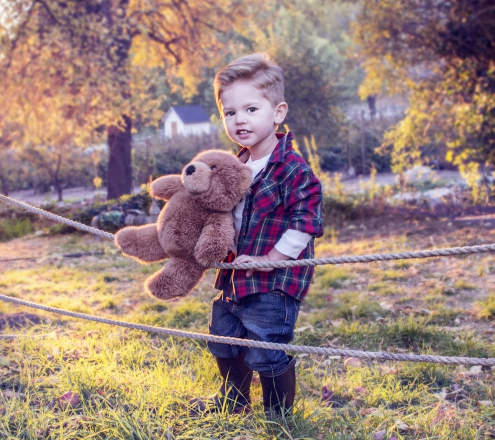 Arafed boy holding a teddy bear on a rope (cool, kid, smart)