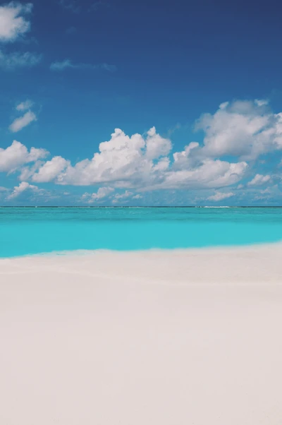 Laguna turquesa y arena blanca prístina bajo un cielo azul