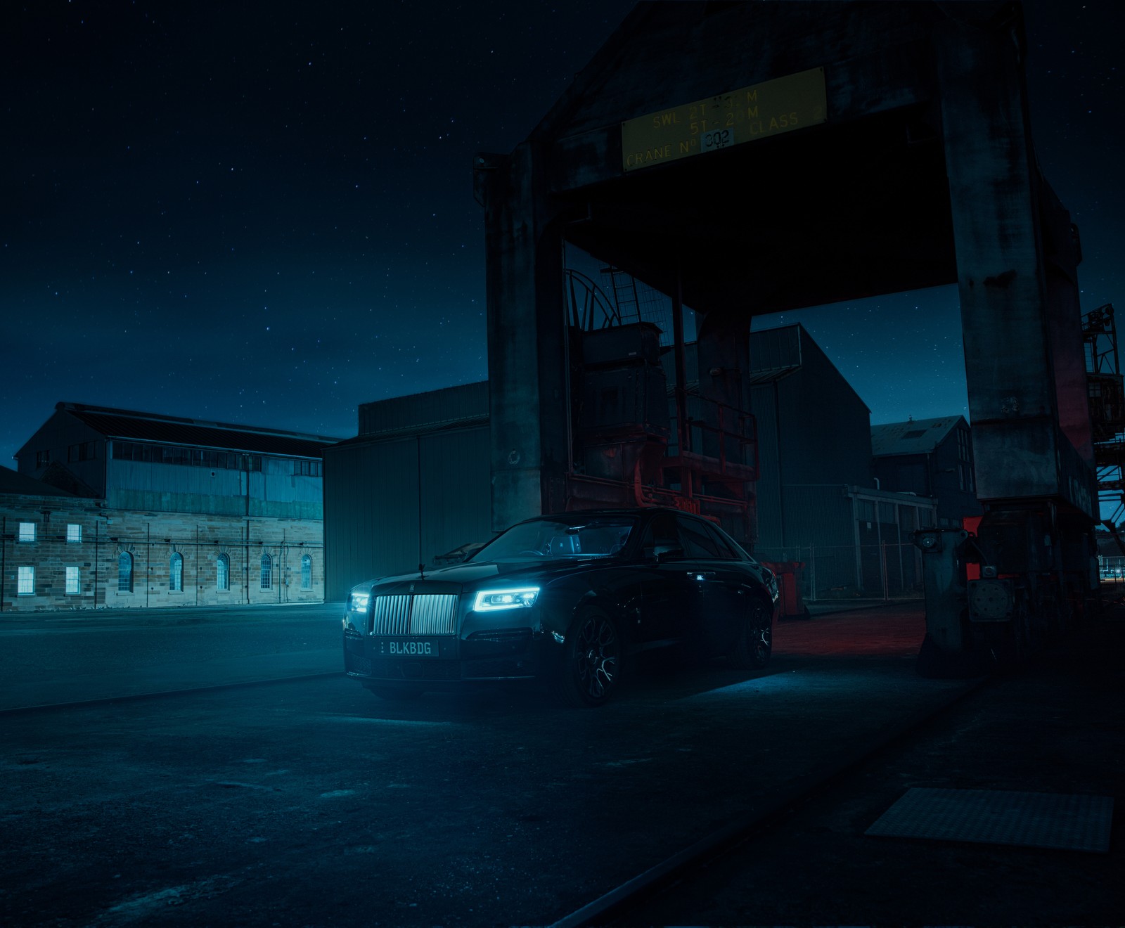 Um carro estacionado em frente a um contêiner de carga à noite (rolls royce black badge ghost, noite, 2022, 5k, 8k)