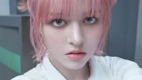 Lily Jin Morrow with pink hair gazes intently at the camera, embodying a captivating and ethereal presence in a concept photo for NMIXX's "Sententia.