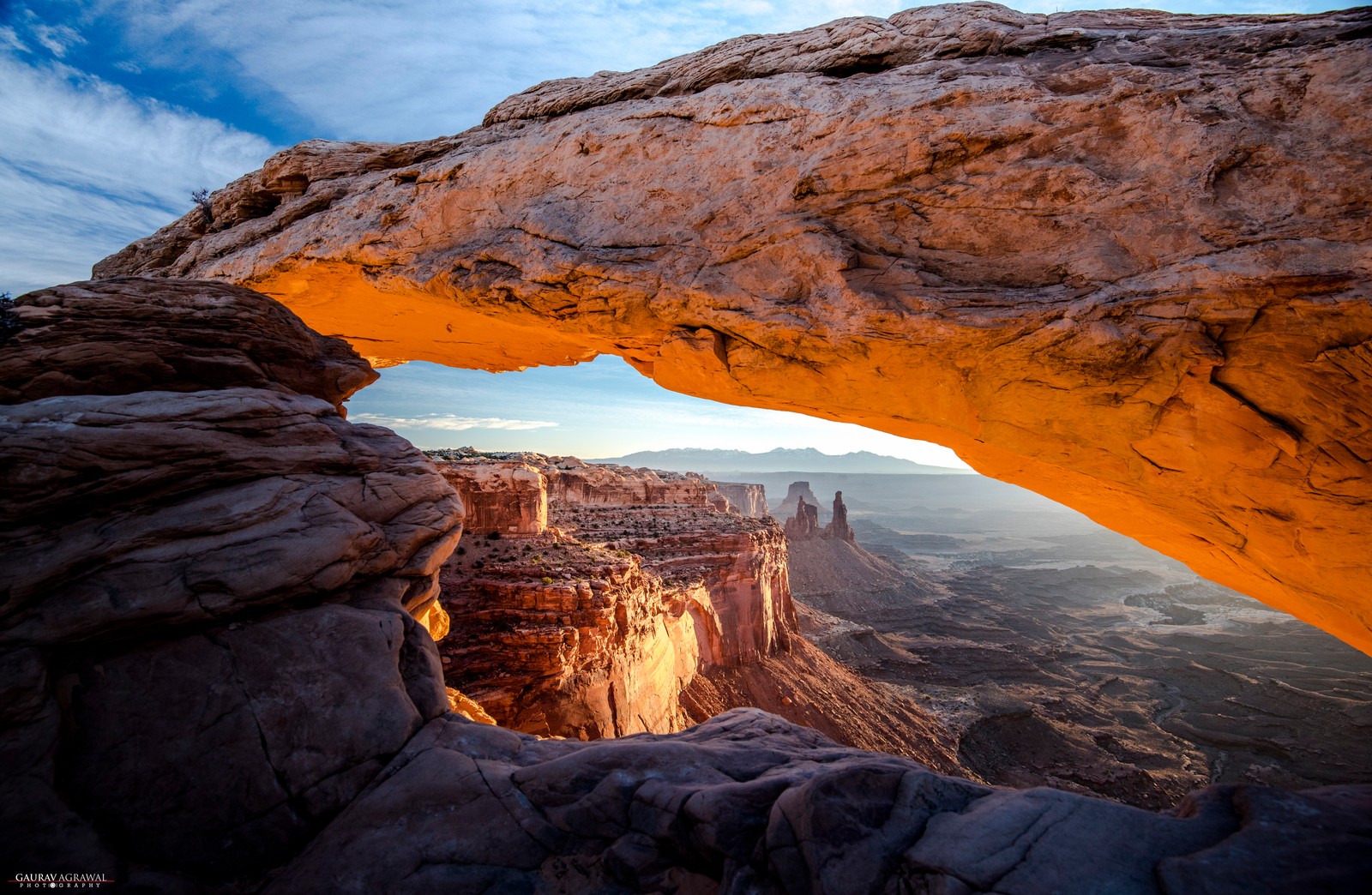 Una vista de una gran formación rocosa con un gran arco en el medio (parque nacional canyonlands, mesa arco, parque nacional bryce canyon, parque nacional, arco natural)