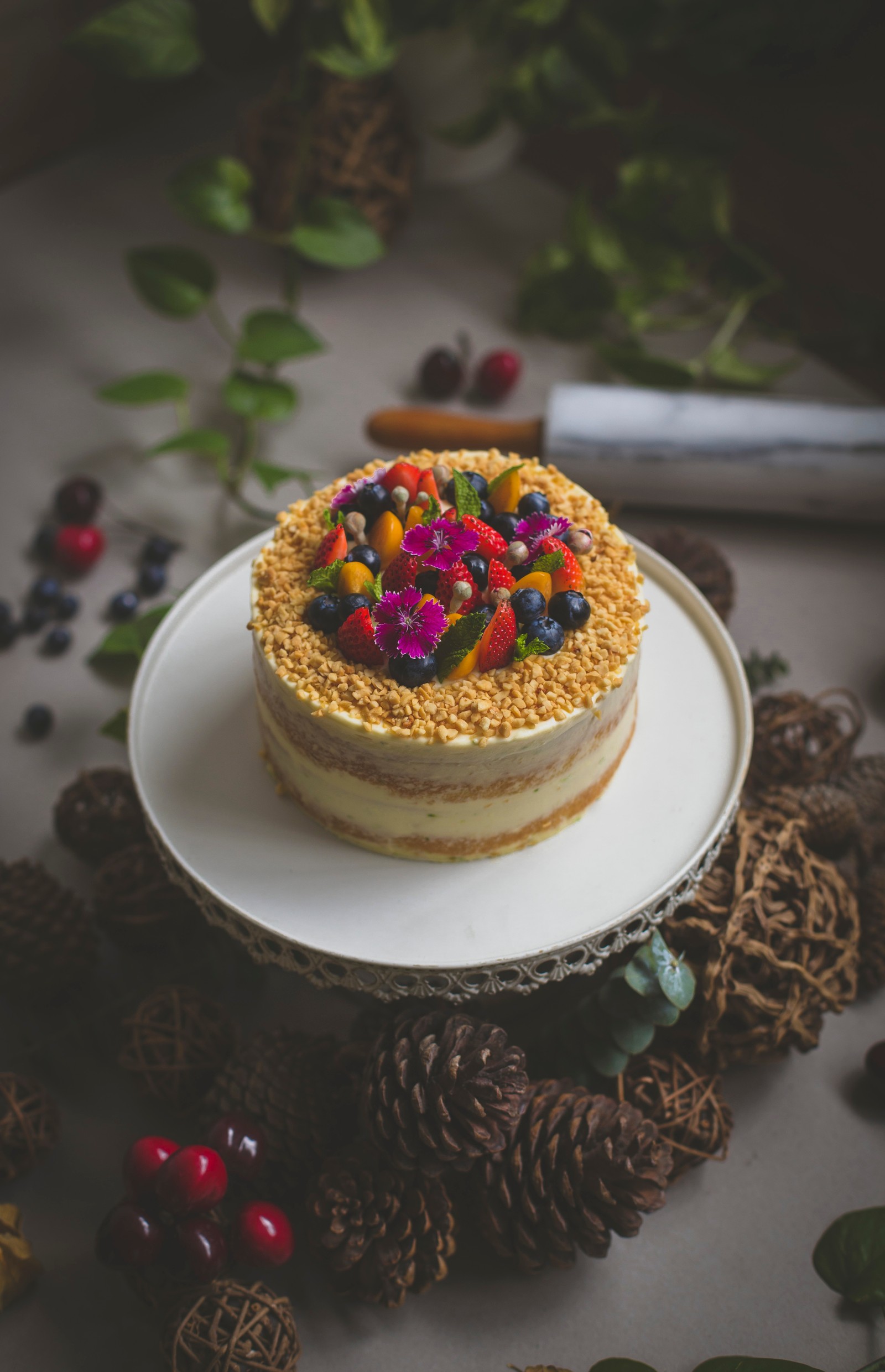 Hay un pastel con frutas encima em um plato (glaseado, pastel, pastel de cumpleaños, horneado, postre)