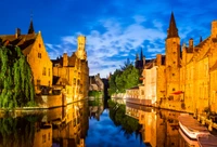 Reflexões da arquitetura medieval no canal de Bruges ao anoitecer