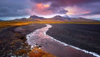 Paysage serein des hautes terres au crépuscule avec des reflets de montagnes dans une rivière.