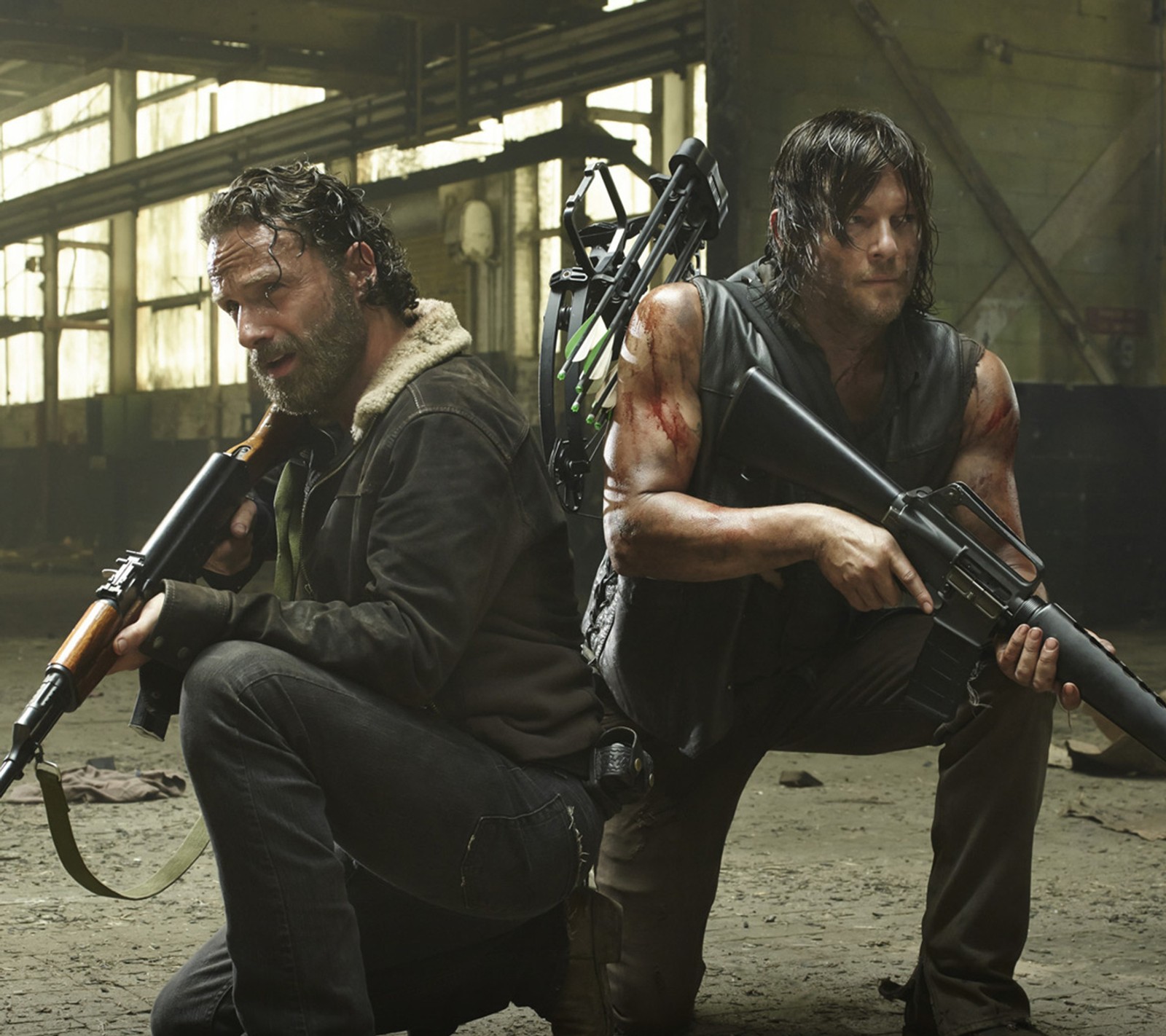 Imagen de dos hombres con armas agachados en un almacén (daryl, muerto, rick, temporada 5, the)