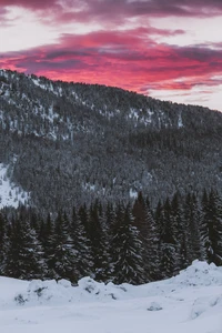 Serene Winter Landscape with Snow-Capped Mountains and Fiery Sunset Sky