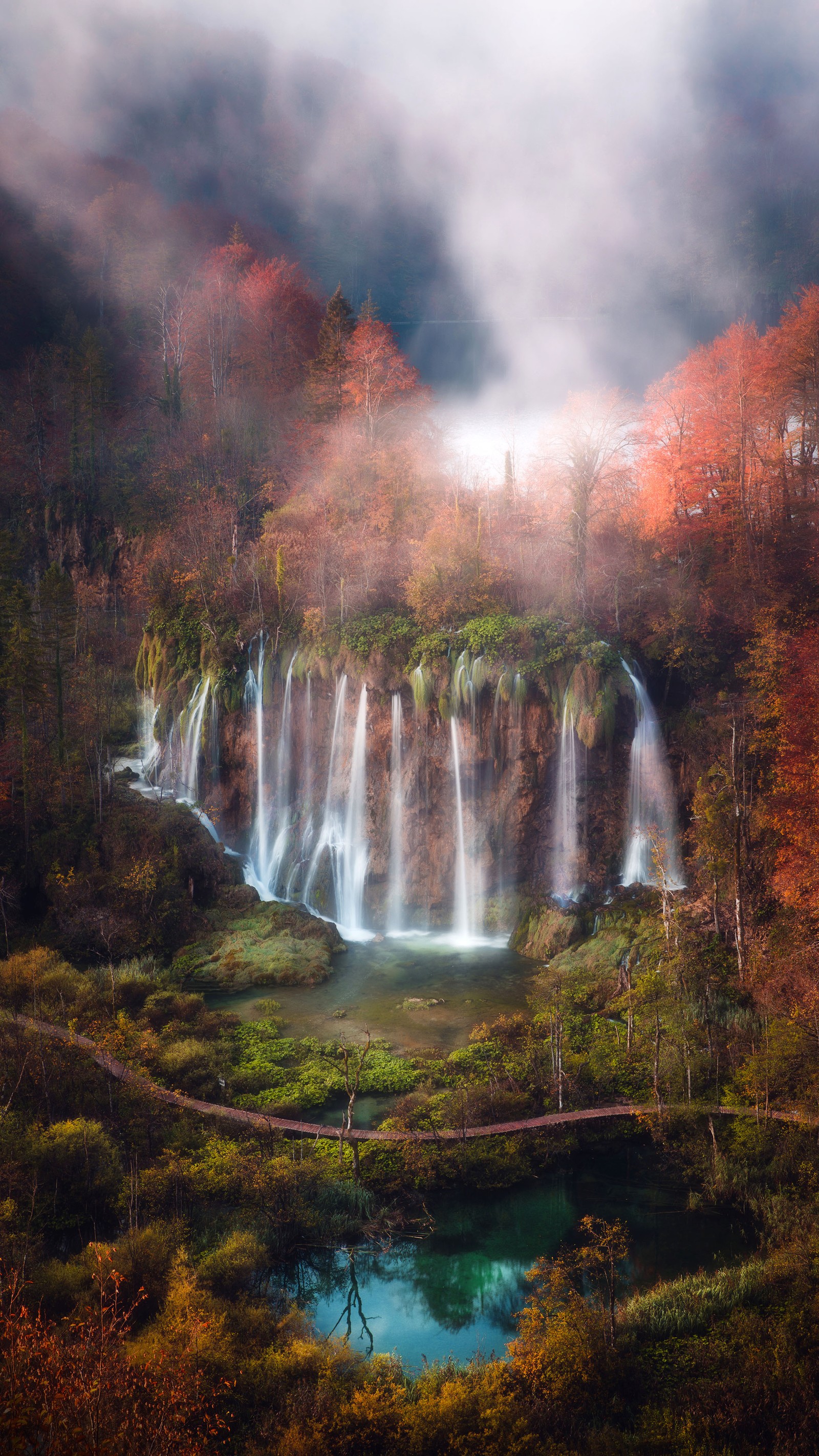 Une cascade au milieu d'une forêt avec un pont au-dessus (parc national des lacs de plitvice, plitvice lakes national park, nature, parc national, attraction touristique)