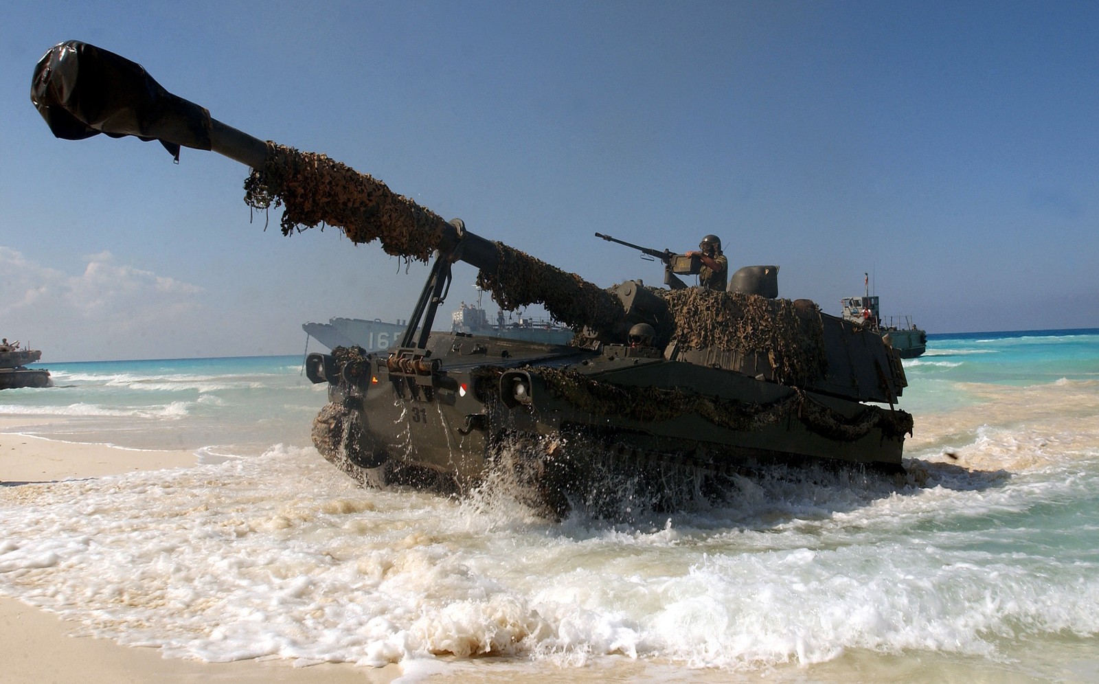 Il y a un char assis dans le sable près de l'eau (char, mer, militaire, sable, arme)